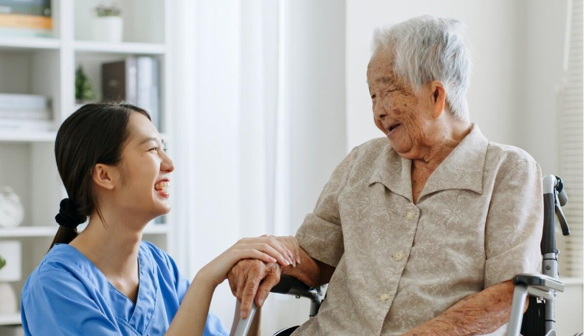 smiling aged care worker with happy older person smiling aged care worker with happy older person